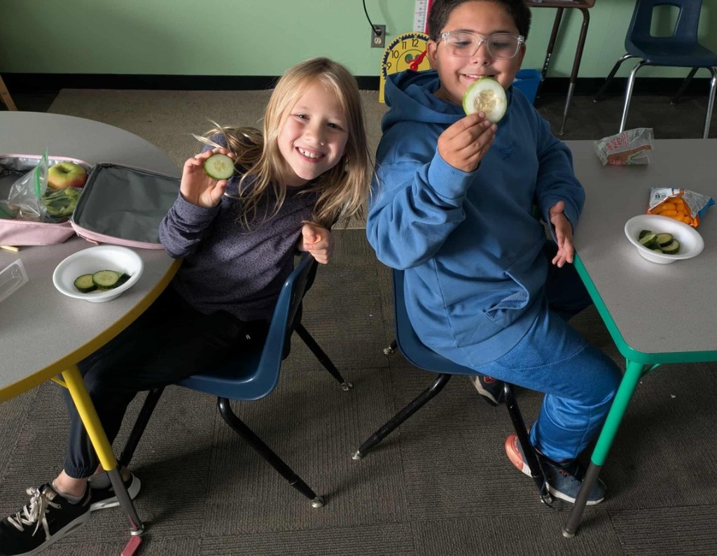 2 kids enjoying cucumbers