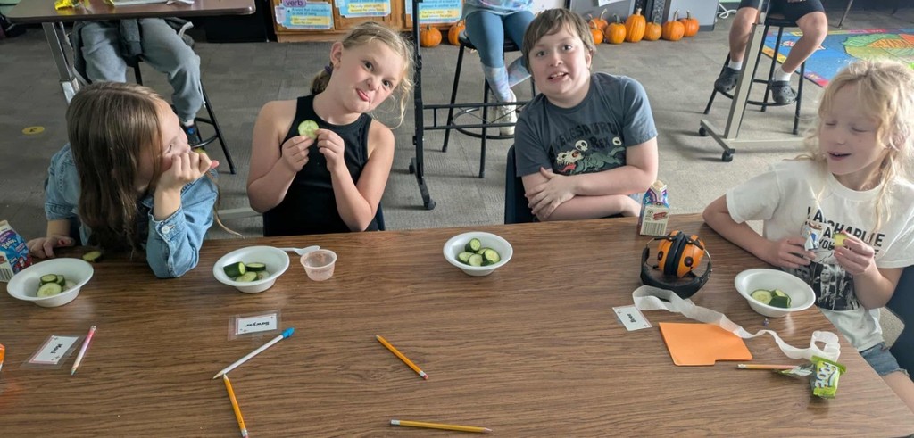 4 kids eating cucumbers