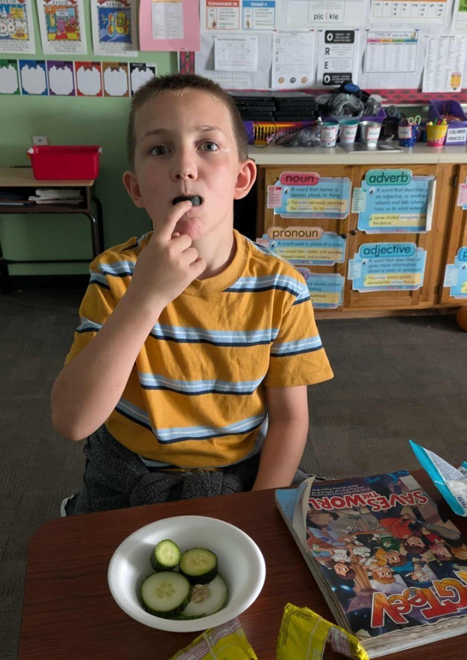 a boy eating a cucmber