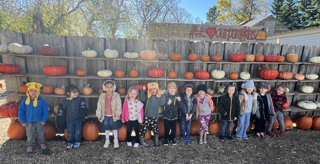 the kids in front of the pumpkins