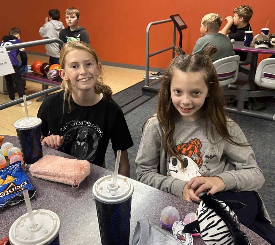 2 5th grade girls visiting at the bowling alley