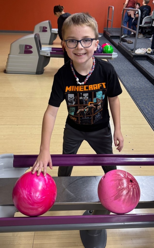 a boy picking a ball and getting ready to bowl