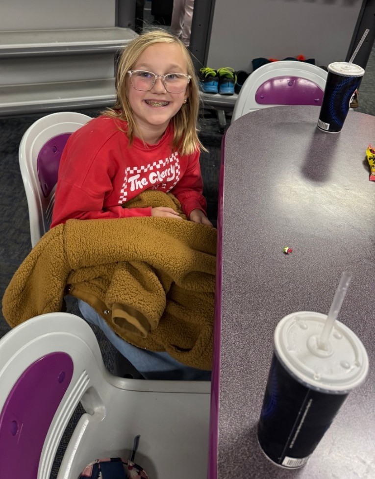a girl waiting her turn and getting a drink.
