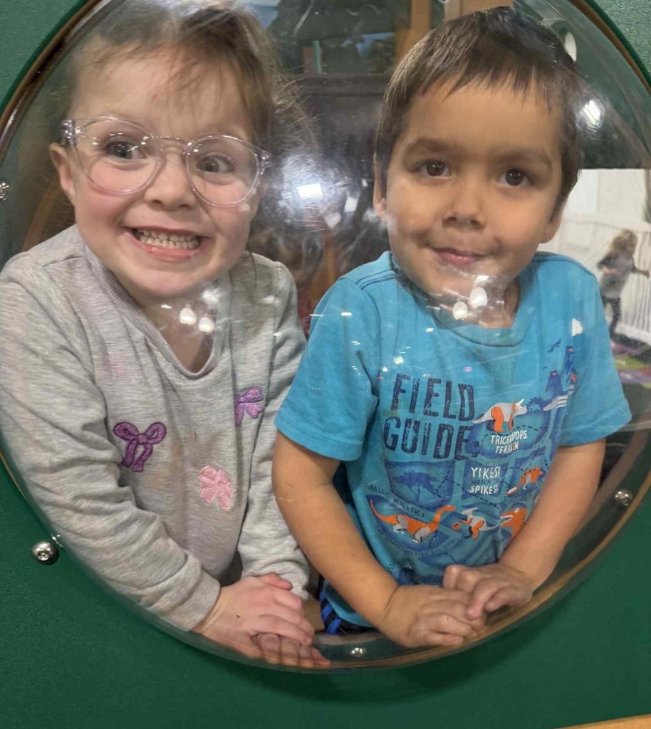 2 friends looking out the round window