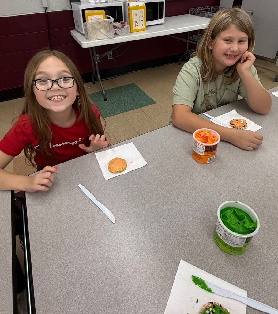 2 girls excited to decorate cookies.