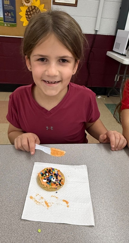 a girl decorating her cookie