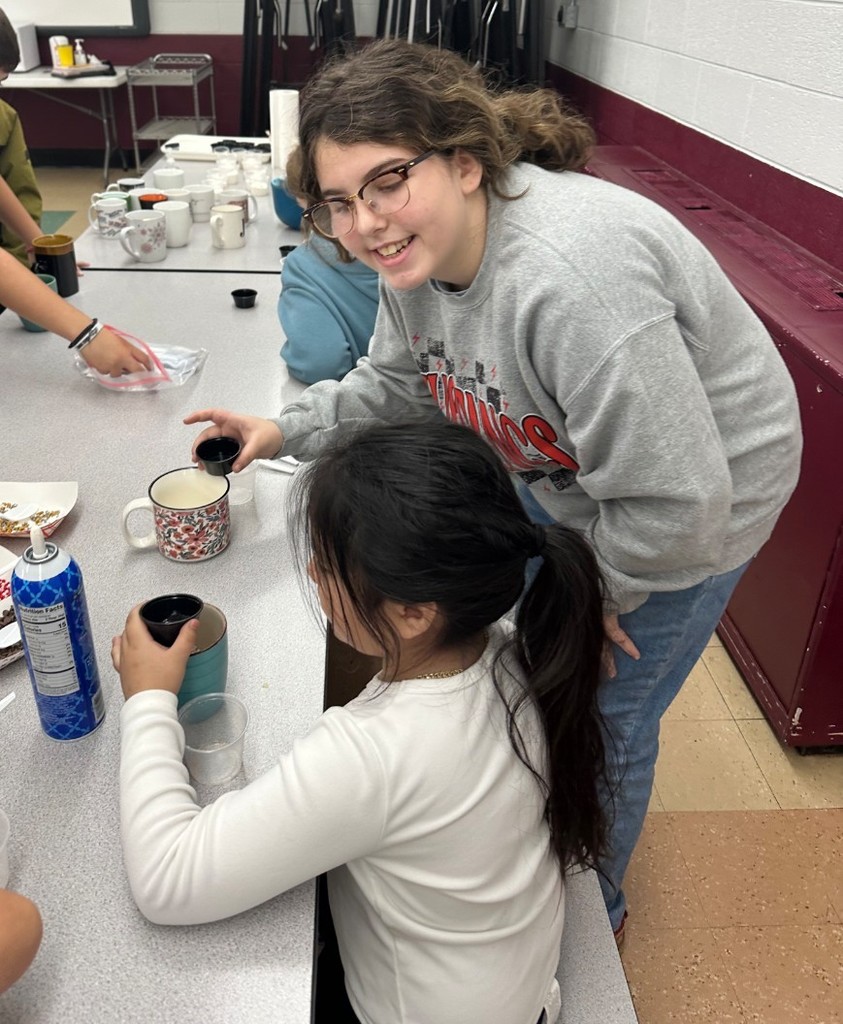 2 girls making a cake