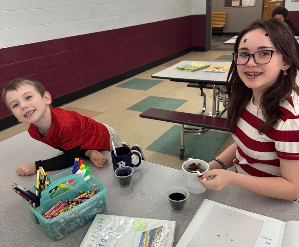 2 kids making mug cakes