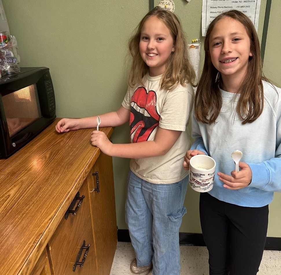 2 girls microwaving their cakes