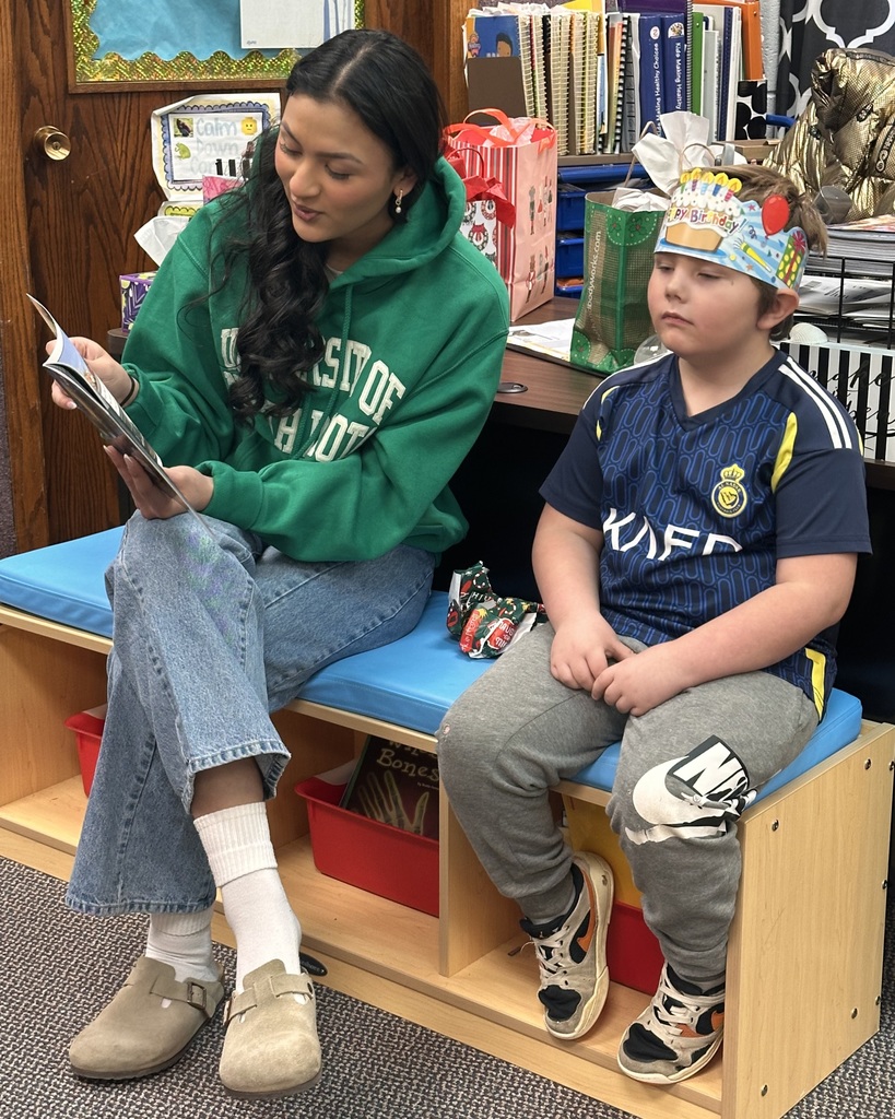 a girl reading to a boy.