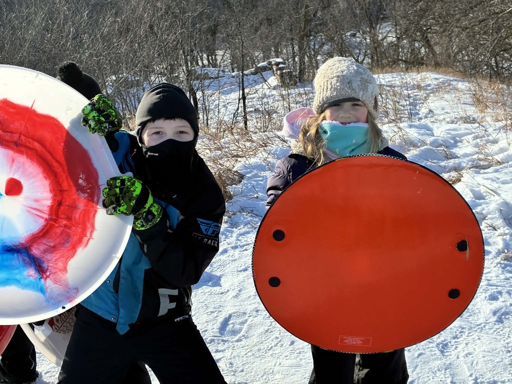kids with sleds on the hill