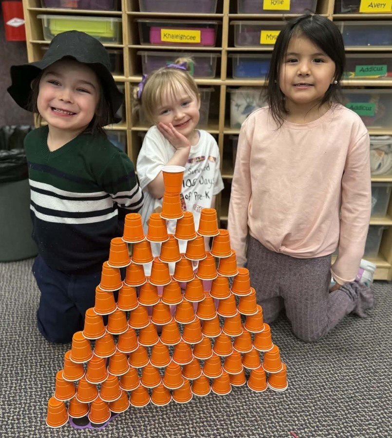 3 kids stacked 100 orange cups.