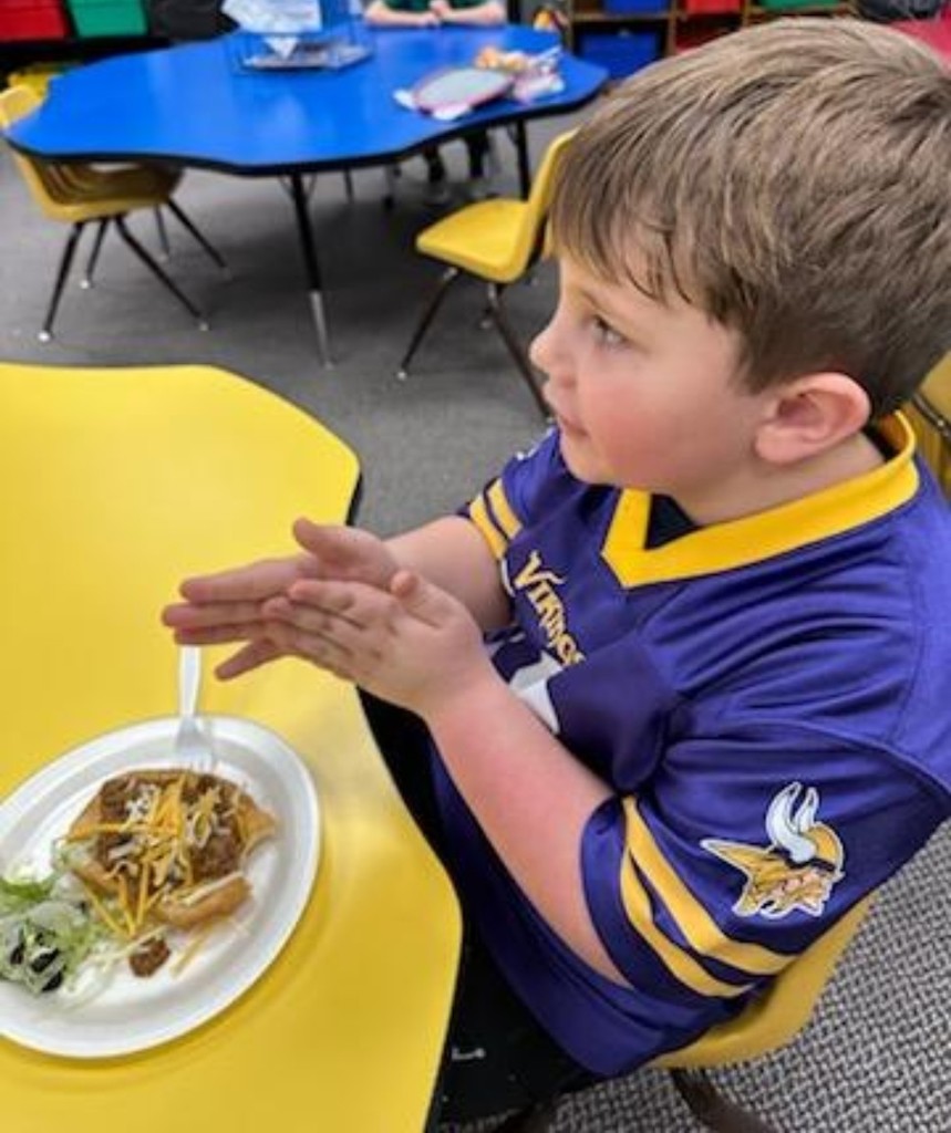 a boy getting ready to eat a taco