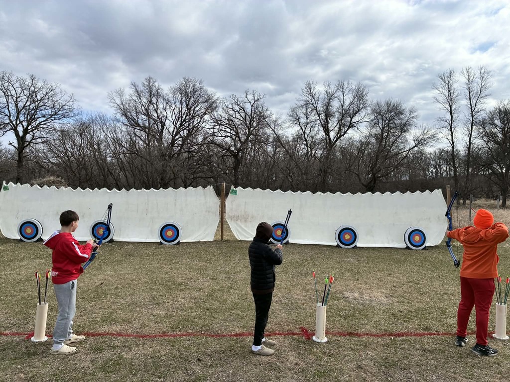 kids shooting with a bow and arrow