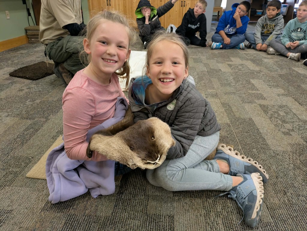 2 girls touching a pelt.