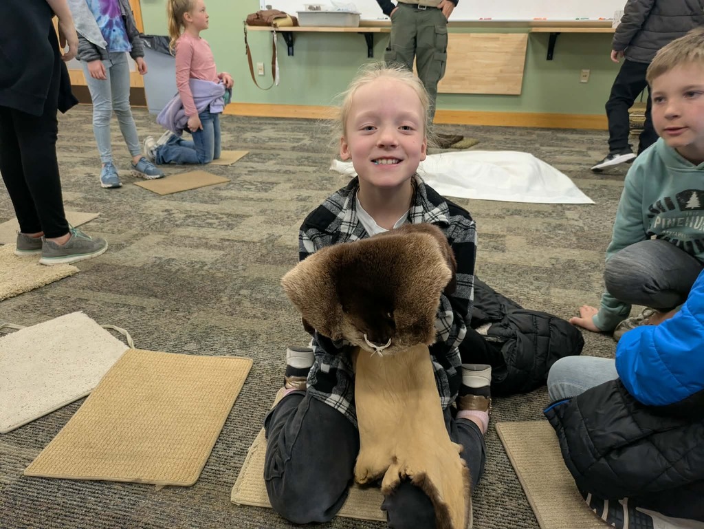 a girl holding a beaver pelt