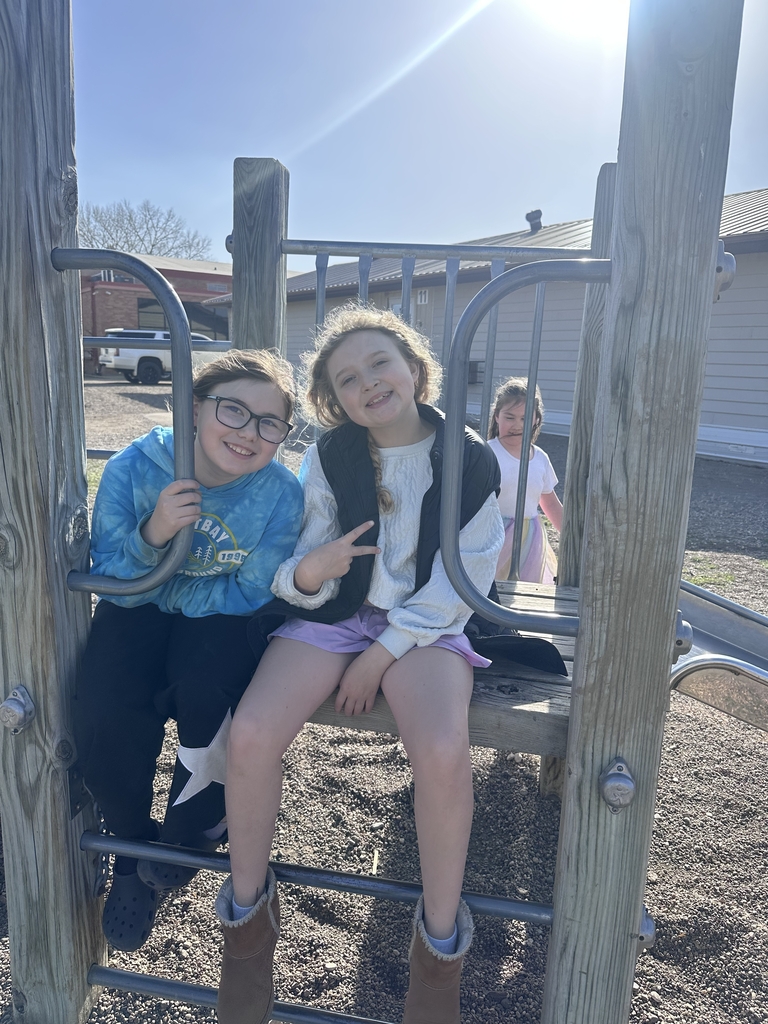 2 girls sitting on the jungle gym