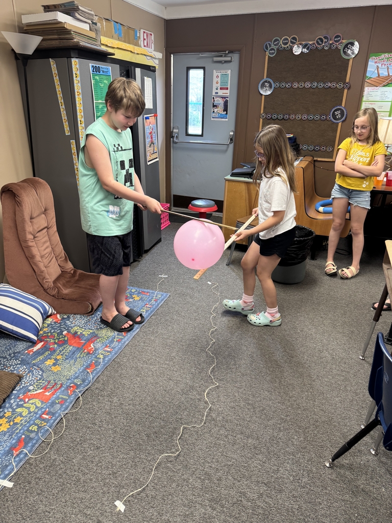 kids carrying balloons with sticks.