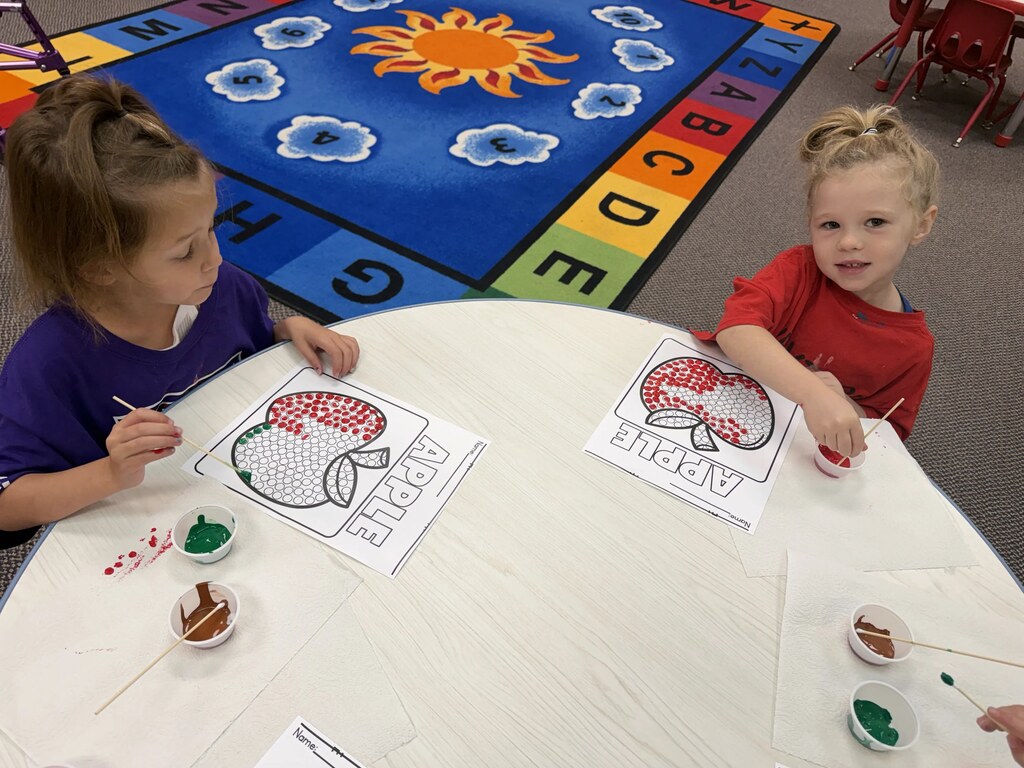 2 girls painting apples