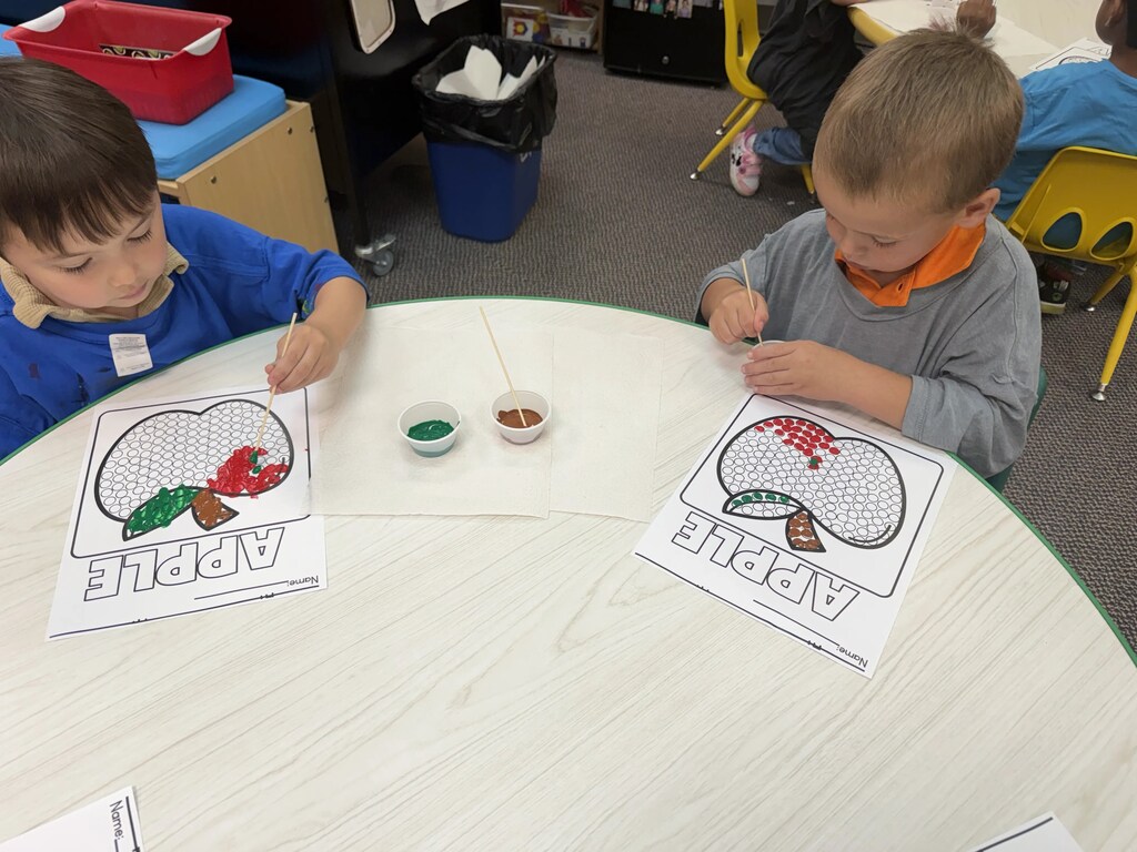 2 boys painting apples