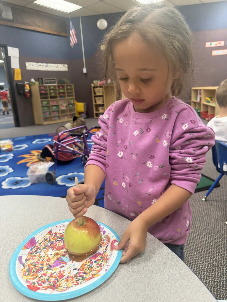 a girl making a caramel apple