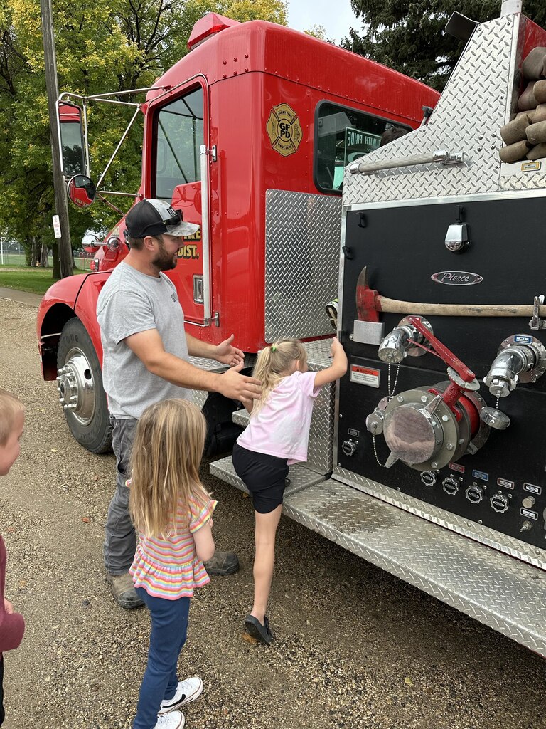 girls climbing into the fire truck