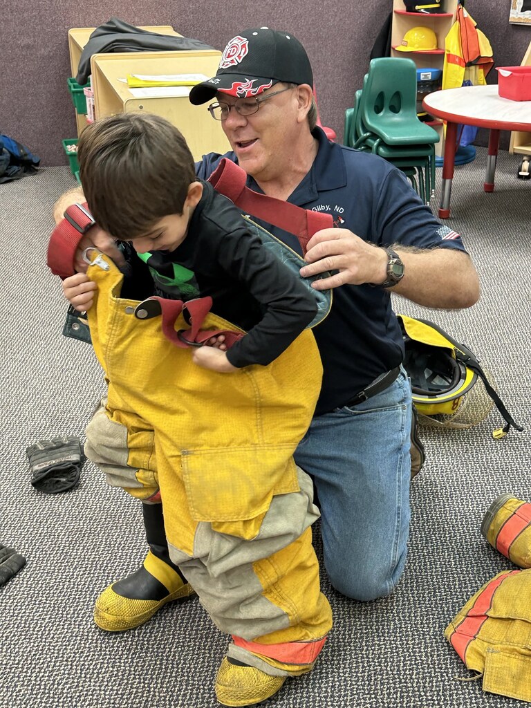 a boy getting the Firefighters gear on