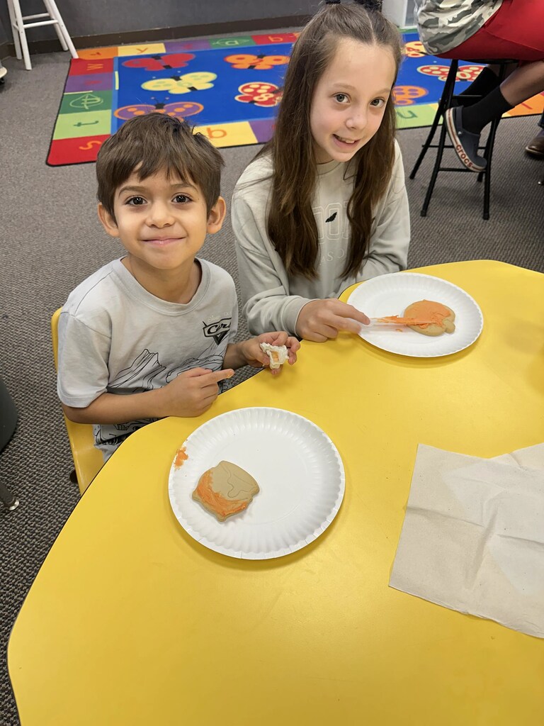 a kid and her buddy eating cookies