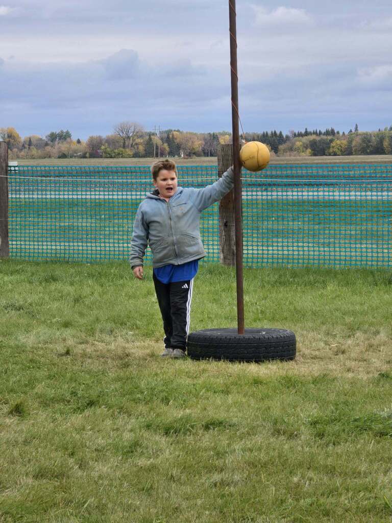 a kid playing tetherball