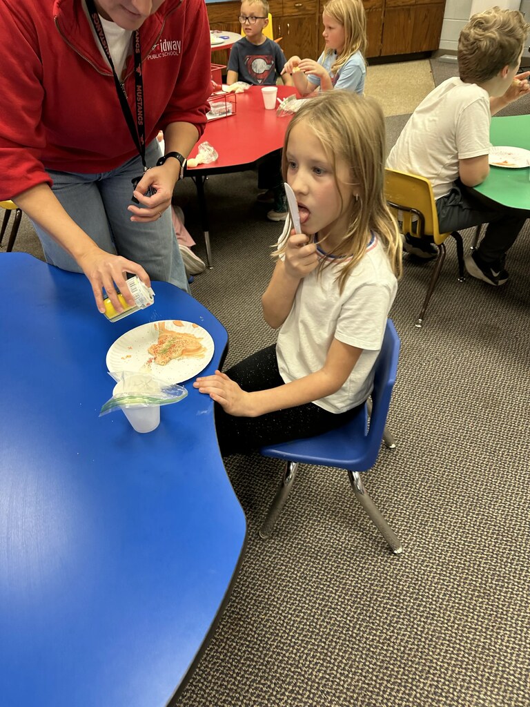 a girl picking a knife with frosting