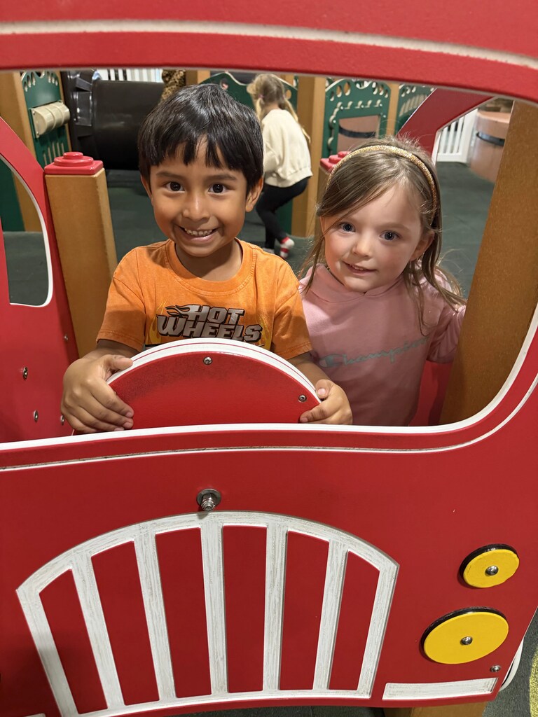 2 kids driving a fire truck