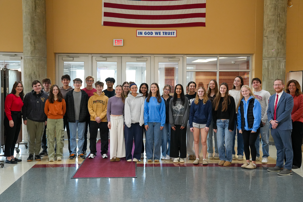 Students standing in front of an American flag