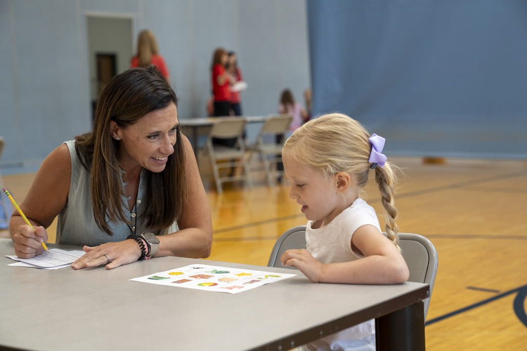 Teacher smiling at blonde child