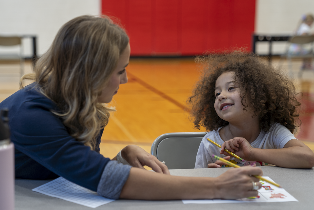 Child smiling at woman with blonde hair