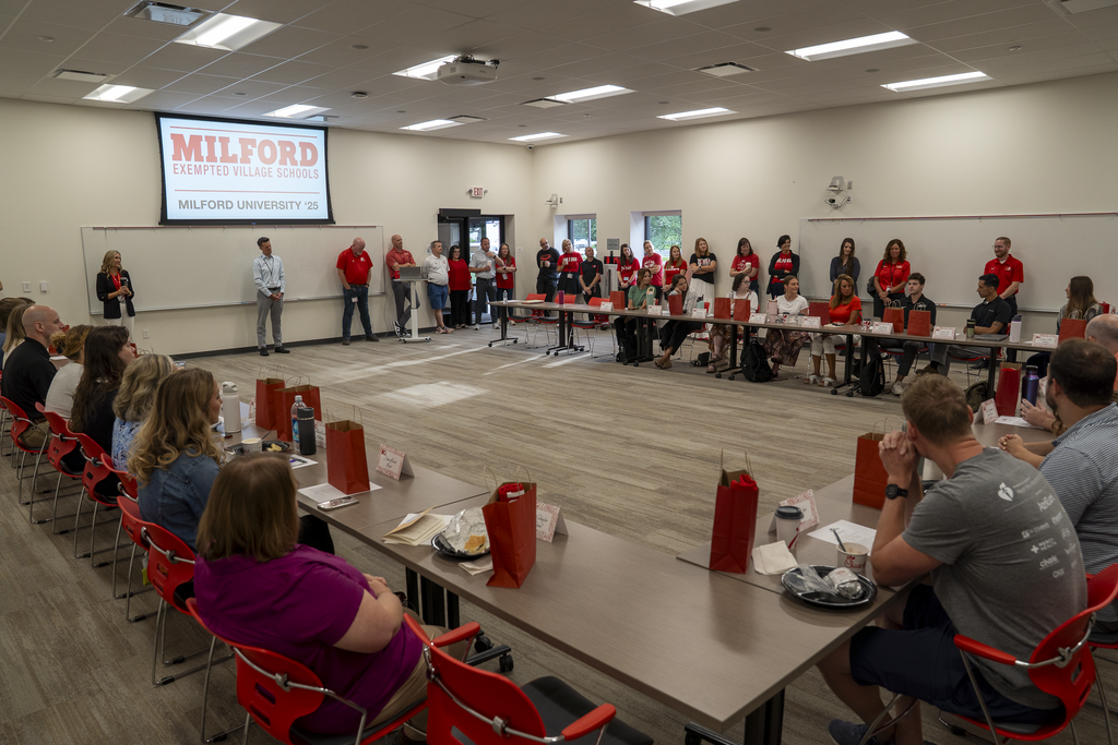 Wide angle photo of many people sitting at desks