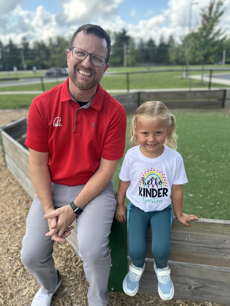 Man in red polo next to girl smiling at the camera