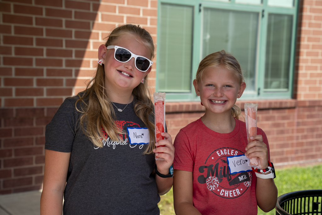 Two Girls Smiling Holding Popsicles