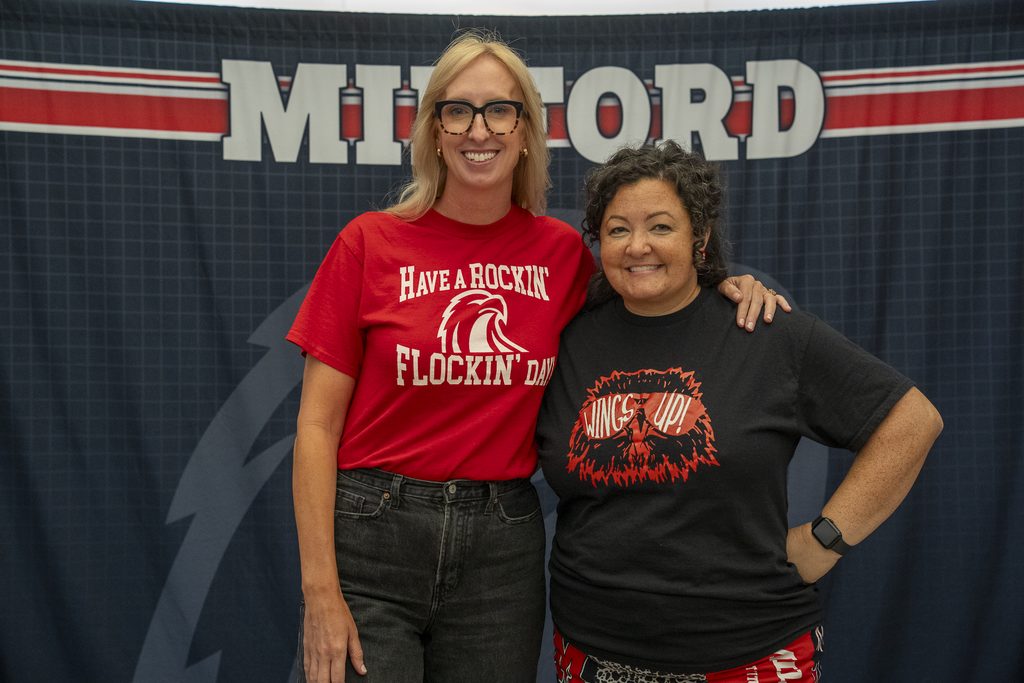 Woman with blonde hair next to shorter woman with black curly hair
