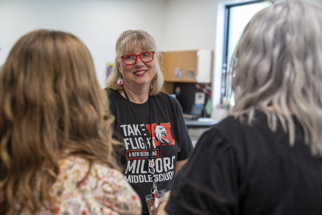 female teacher with red glasses smiling while talking