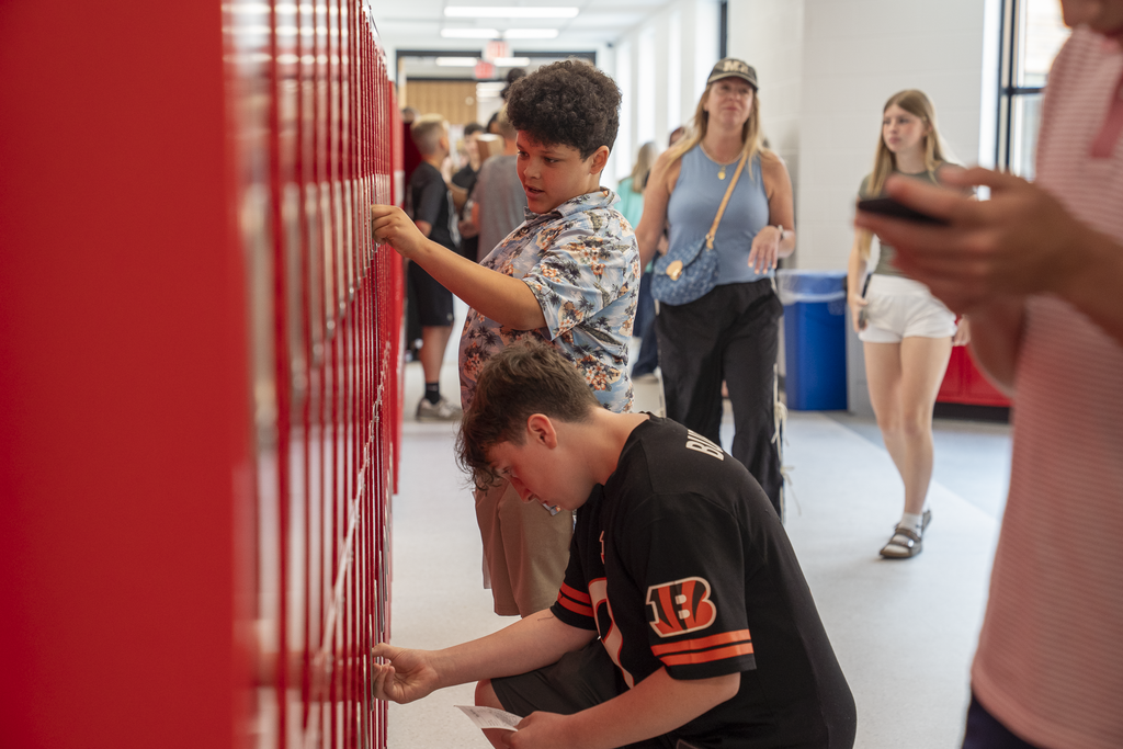 Two students tying to get into their red lockers
