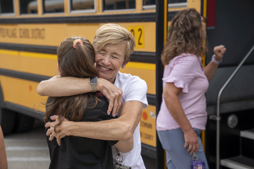 teacher giving a very big hug to a student