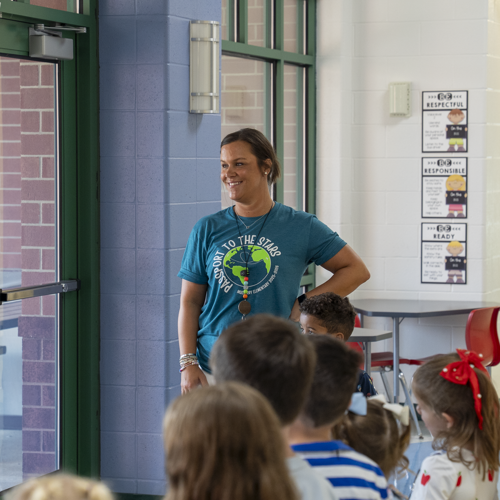Teacher wearing a seipelt shirt smiling in the distance