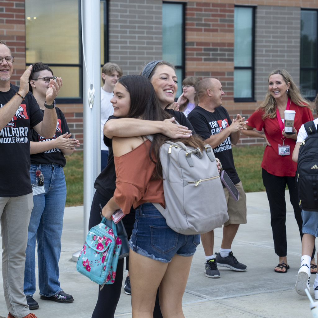 Female teacher giving a hug to a middle school female