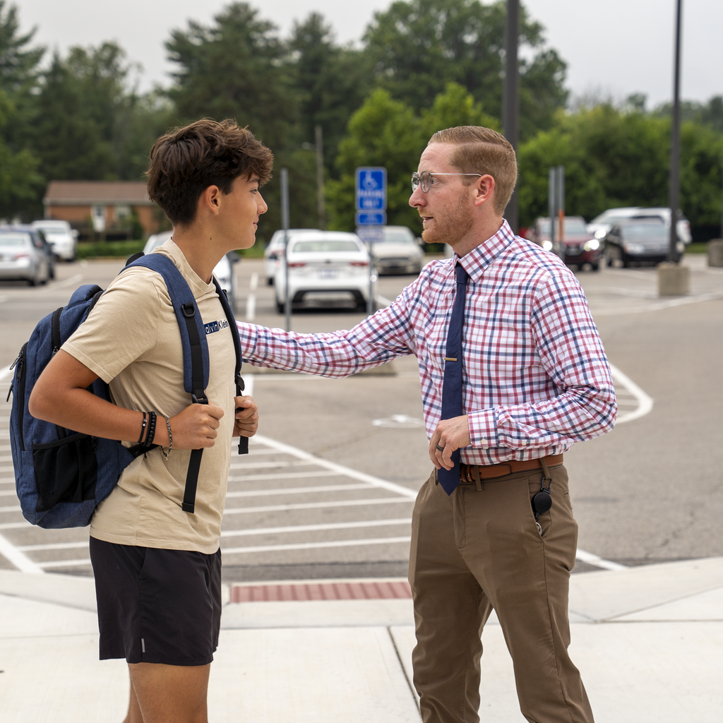young boy receiving wisdom from a man with a tie