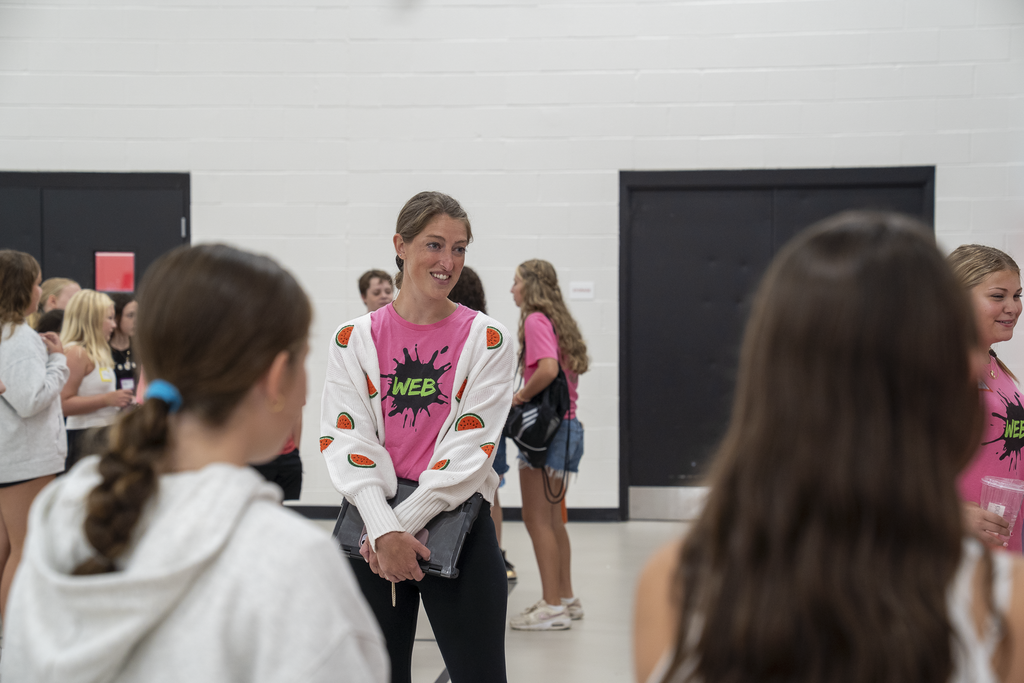 woman in pink shirt and watermelon jacket smiling