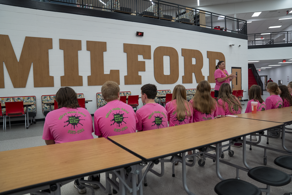 back of students facing "Milford" sign