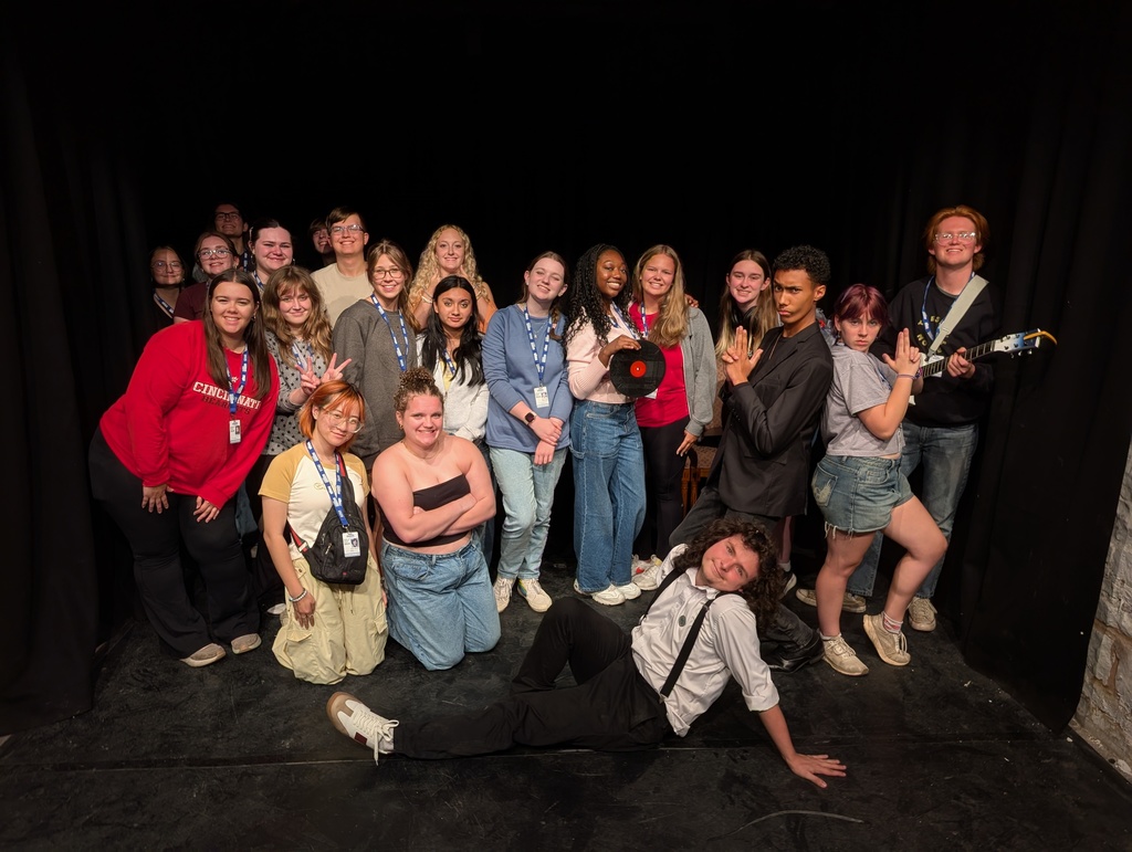 A group photo of 21 students all together on a small stage
