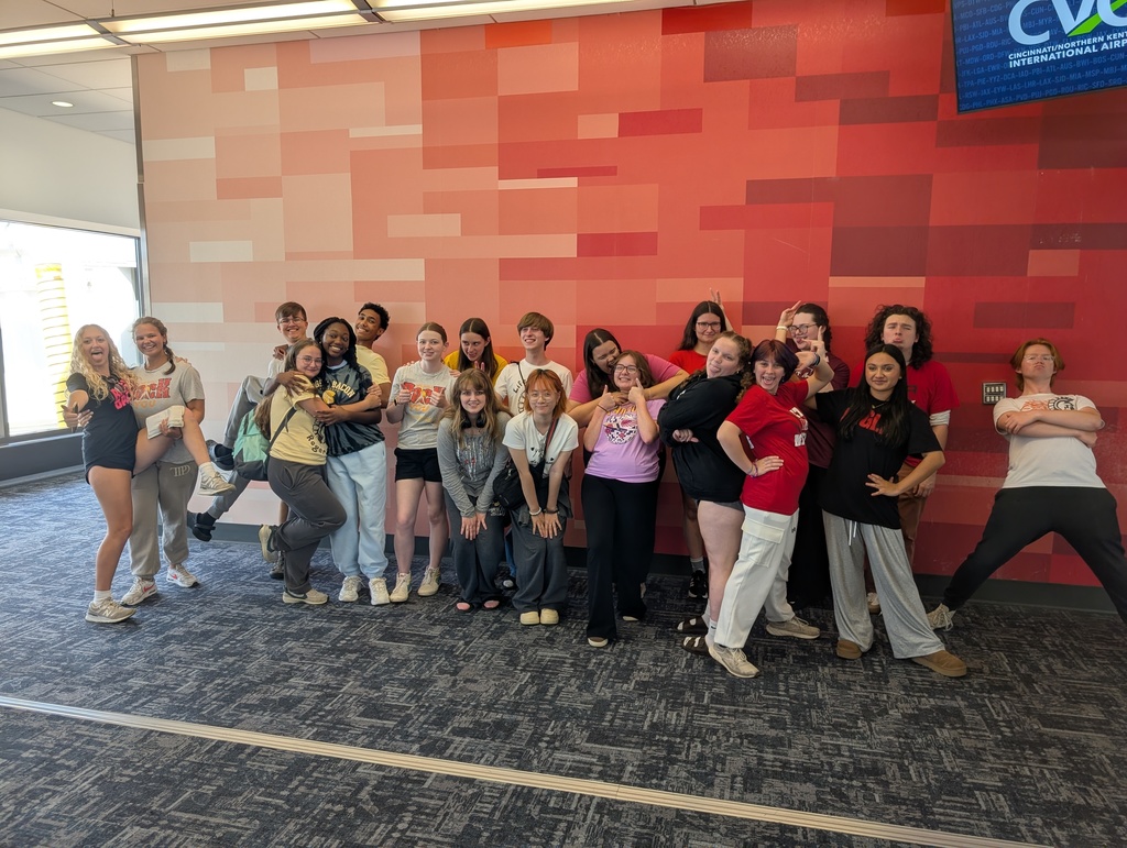 Group of students in front of a red paneled wall
