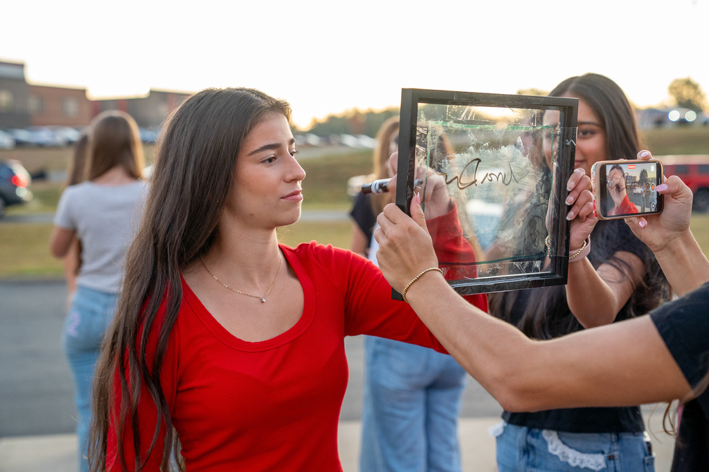 A girl writing her name on the picture frame