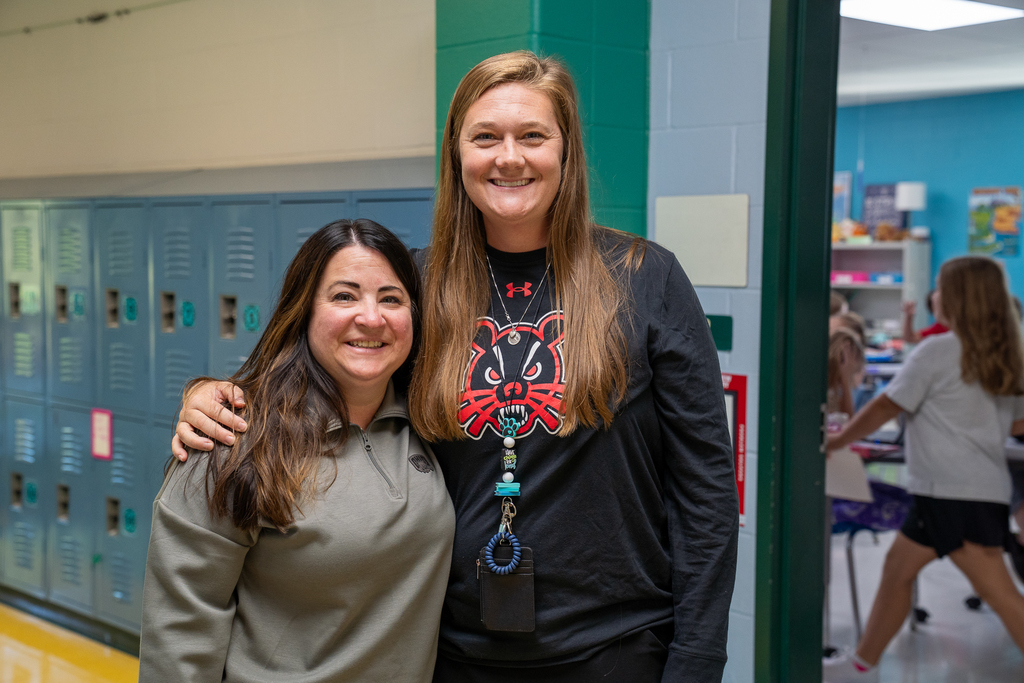 Woman with a Ohio State Pullover next to a woman wearing a UC Bearcat cartoon shirt